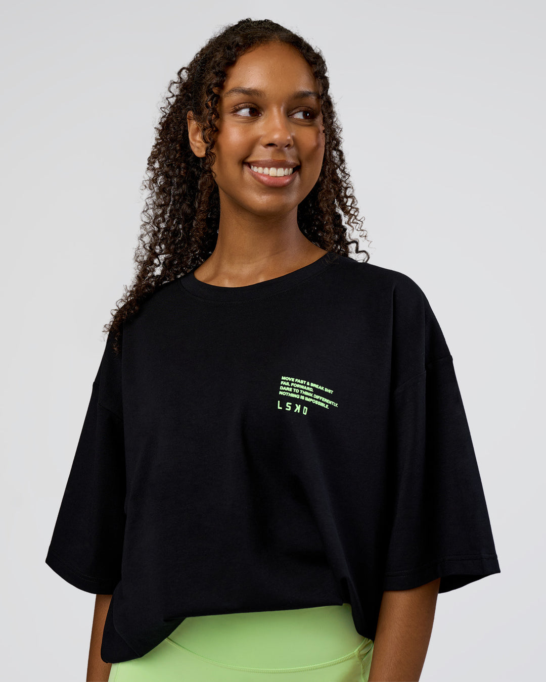 Woman wearing Coffee Run FLXCotton Oversized Tee - Black-Solar Lime | Model:Jordan | Size:L