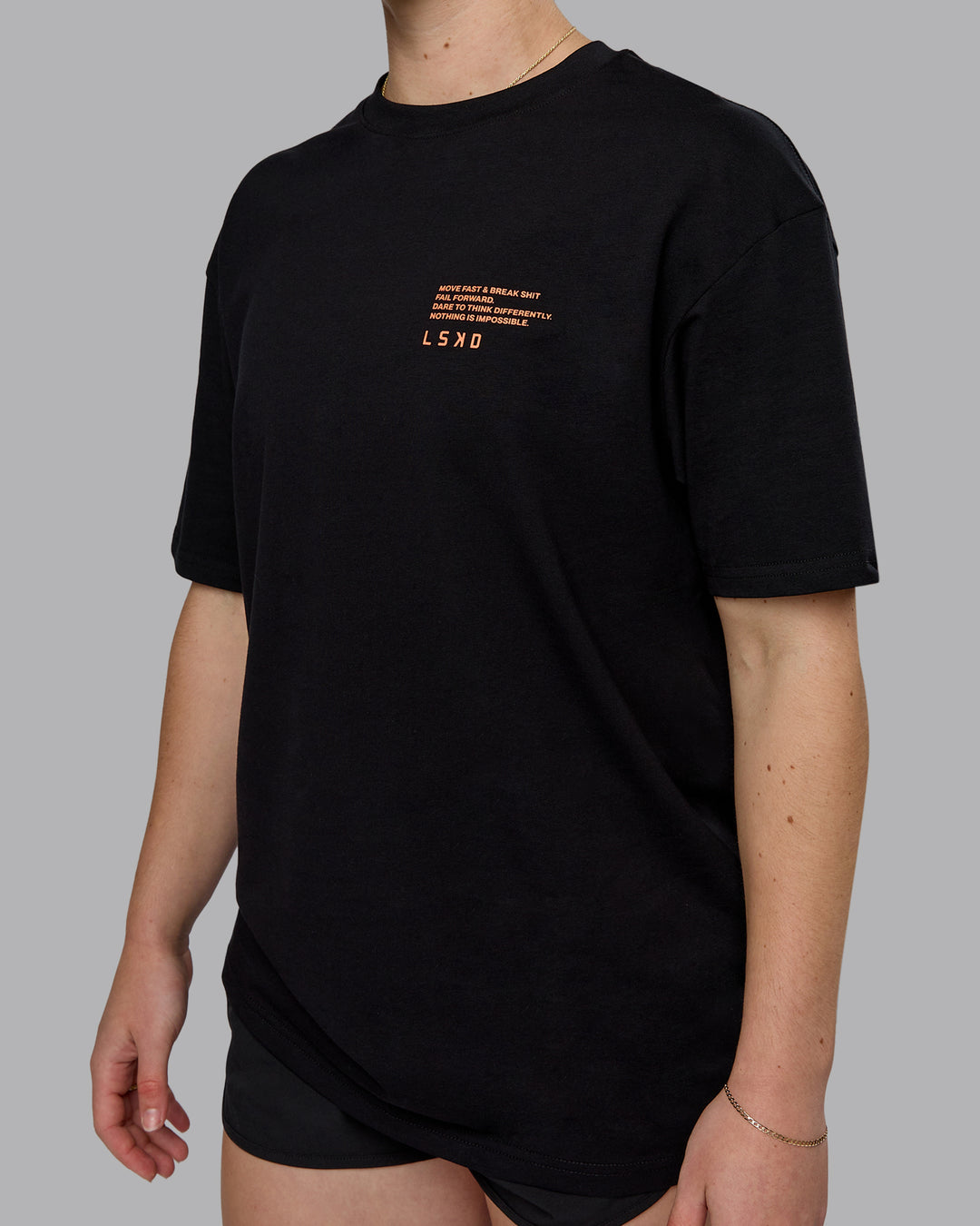 Woman wearing Coffee Run FLXCotton Oversized Tee - Black-Ultra Orange | Model:Sav | Size:XS