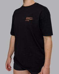 Woman wearing Coffee Run FLXCotton Oversized Tee - Black-Ultra Orange | Model:Sav | Size:XS
