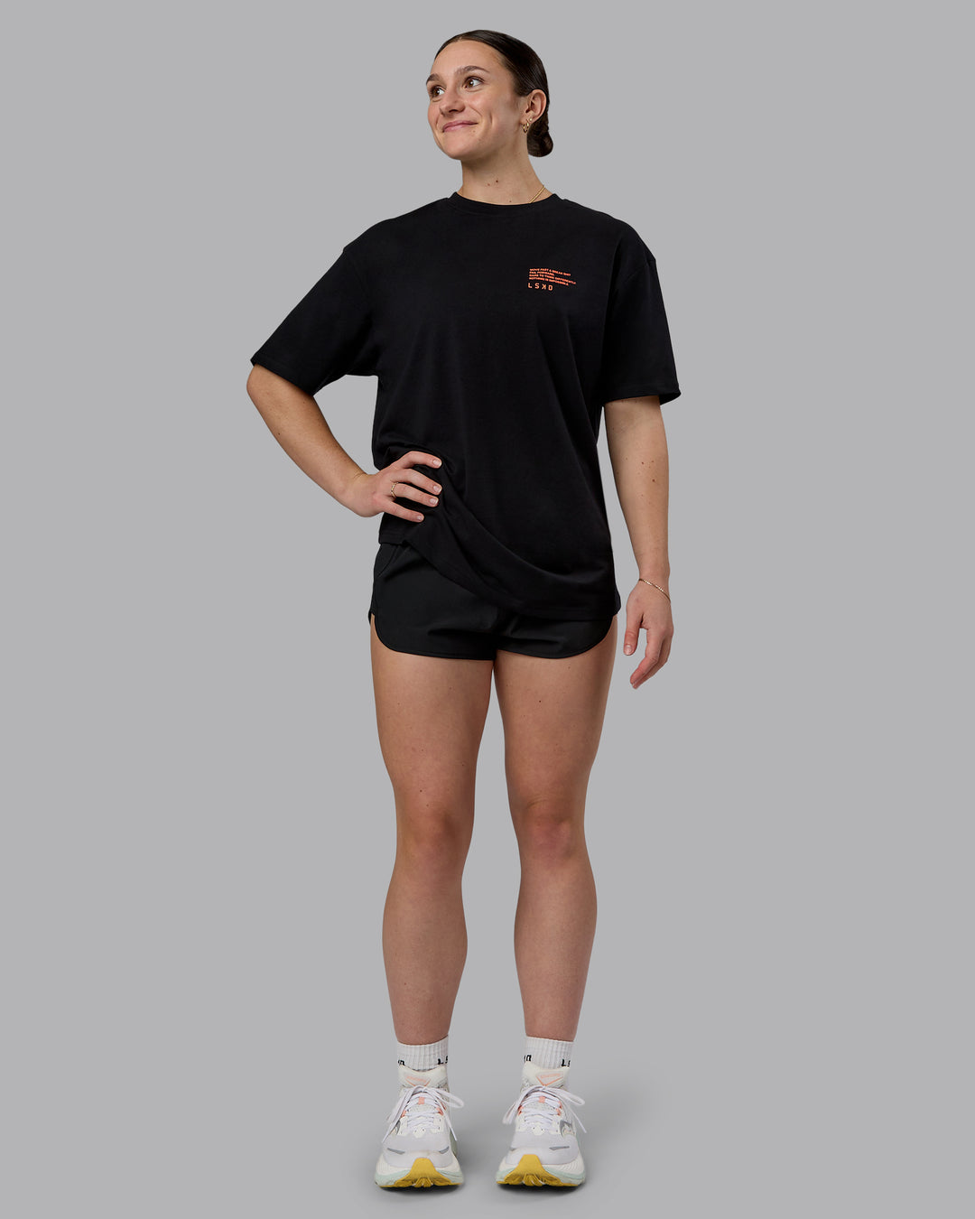 Woman wearing Coffee Run FLXCotton Oversized Tee - Black-Ultra Orange | Model:Sav | Size:XS