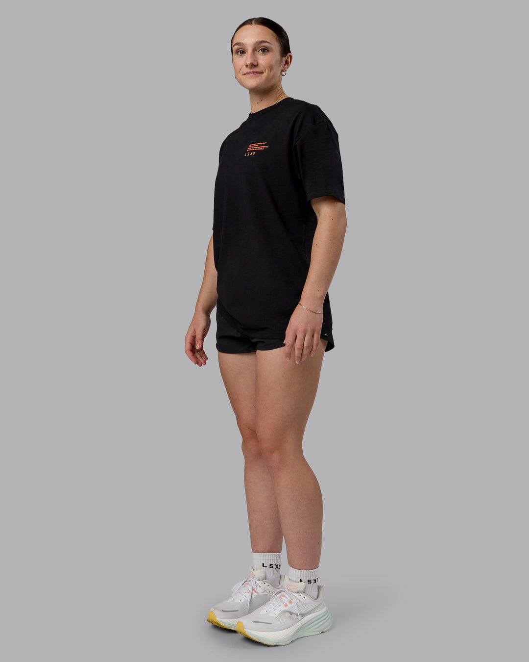 Woman wearing Coffee Run FLXCotton Oversized Tee - Black-Ultra Orange | Model:Sav | Size:XS