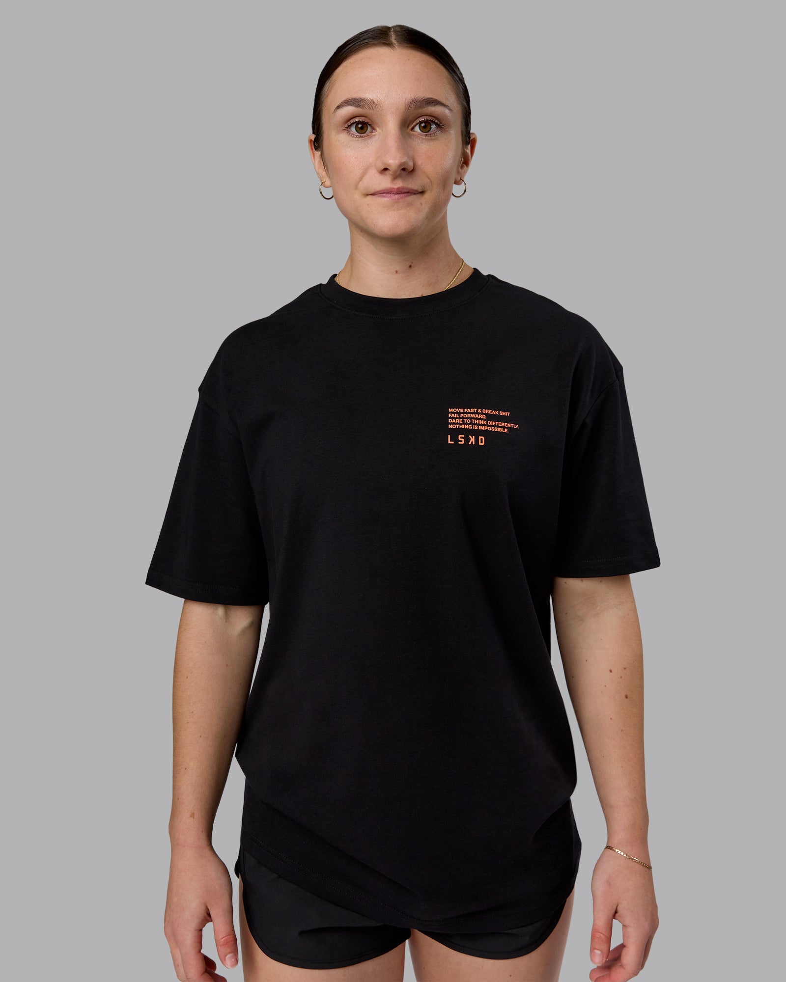 Woman wearing Coffee Run FLXCotton Oversized Tee - Black-Ultra Orange | Model:Sav | Size:XS