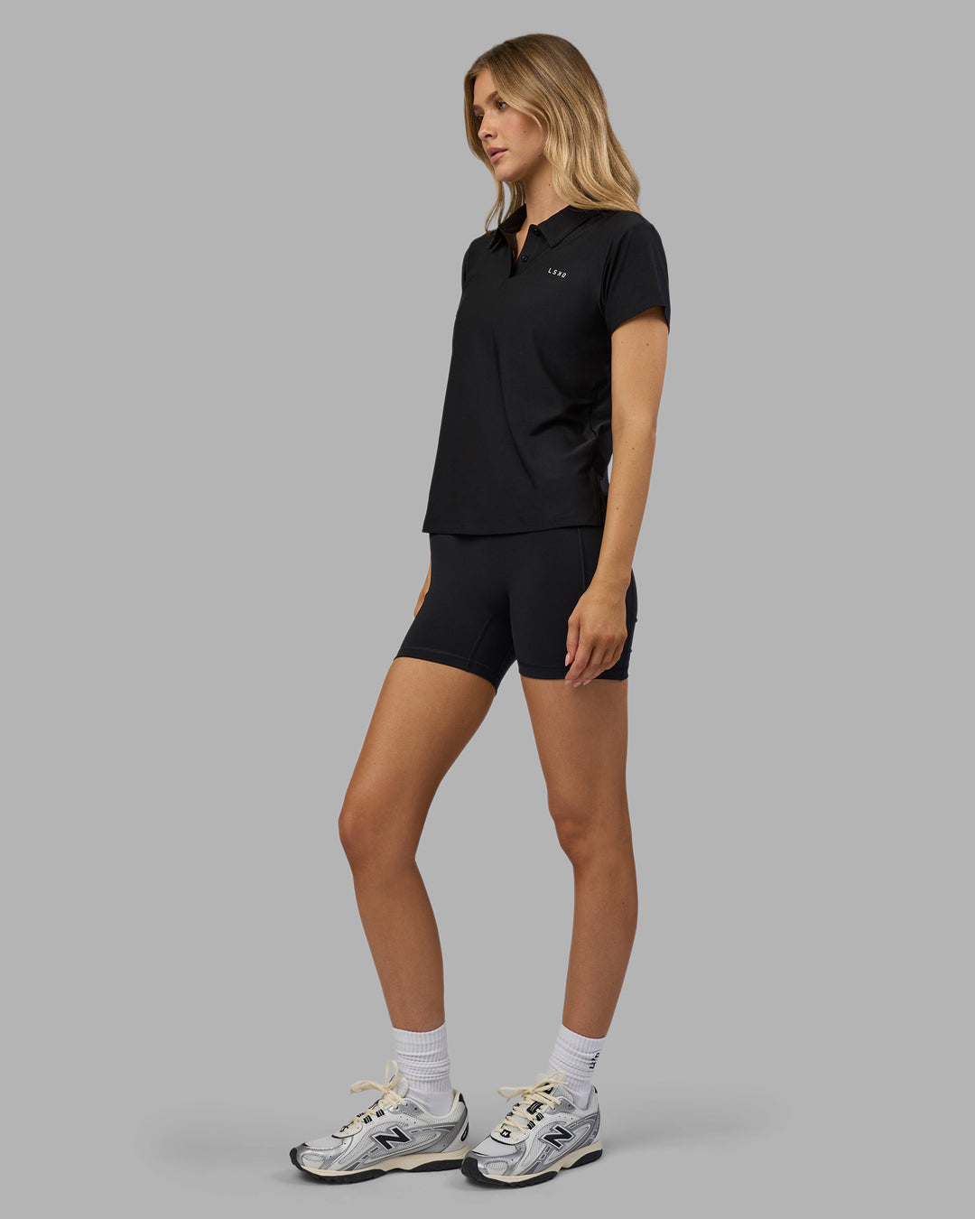 Woman wearing Drive Polo - Black | Model:Leilani| Size:XS