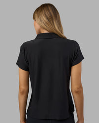 Woman wearing Drive Polo - Black | Model:Leilani| Size:XS