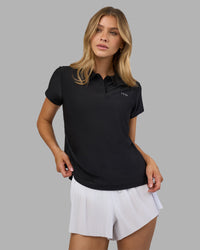 Woman wearing Drive Polo - Black | Model:Leilani| Size:XS