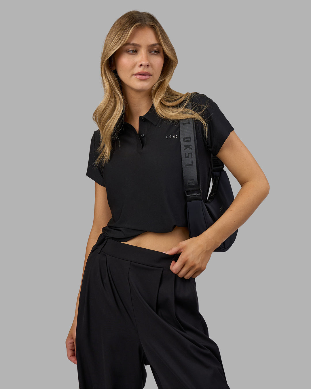 Woman wearing Drive Polo - Black | Model:Leilani| Size:XS