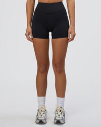 Woman wearing Elite High-Rise 4" Short Pockets - Black | Model:Eliza | Size:XS