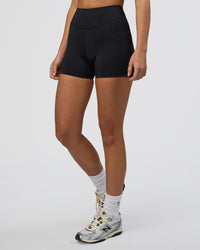 Woman wearing Elite High-Rise 4" Short Pockets - Black | Model:Eliza | Size:XS