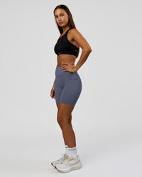 Woman wearing Elite Run High-Rise 7" Short Pockets - Night Shadow | Model:Brylee | Size:XS