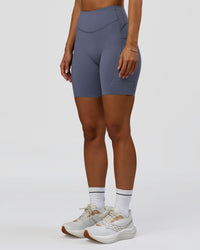 Woman wearing Elite Run High-Rise 7" Short Pockets - Night Shadow | Model:Brylee | Size:XS