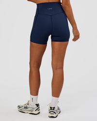 Woman wearing Elixir Ultra High-Rise 4" Short Pockets - Future Navy | Model:Brylee | Size:XS