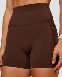 Woman wearing Elixir Ultra High-Rise 4" Short Pockets - Hot Chocolate | Model:Maja | Size:XS