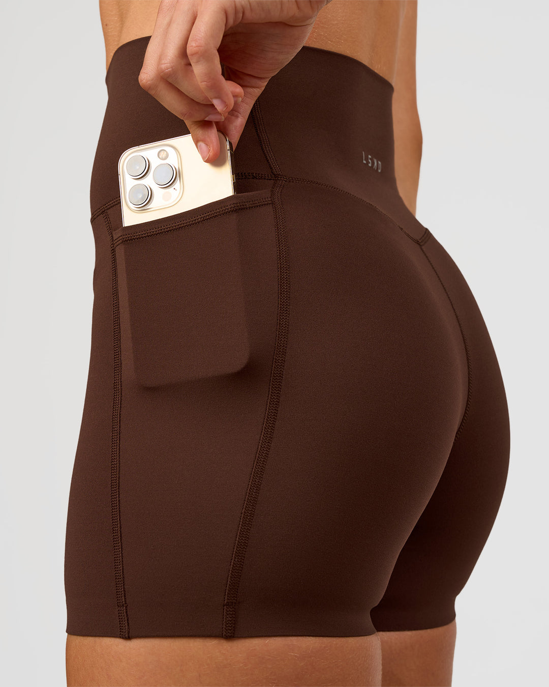 Woman wearing Elixir Ultra High-Rise 4" Short Pockets - Hot Chocolate | Model:Maja | Size:XS