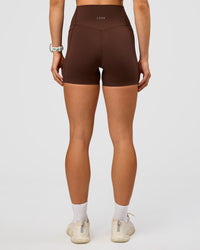 Woman wearing Elixir Ultra High-Rise 4" Short Pockets - Hot Chocolate | Model:Maja | Size:XS