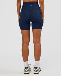 Woman wearing Elixir Ultra High-Rise 6” Short Pockets - Future Navy | Model:Brylee | Size:XS