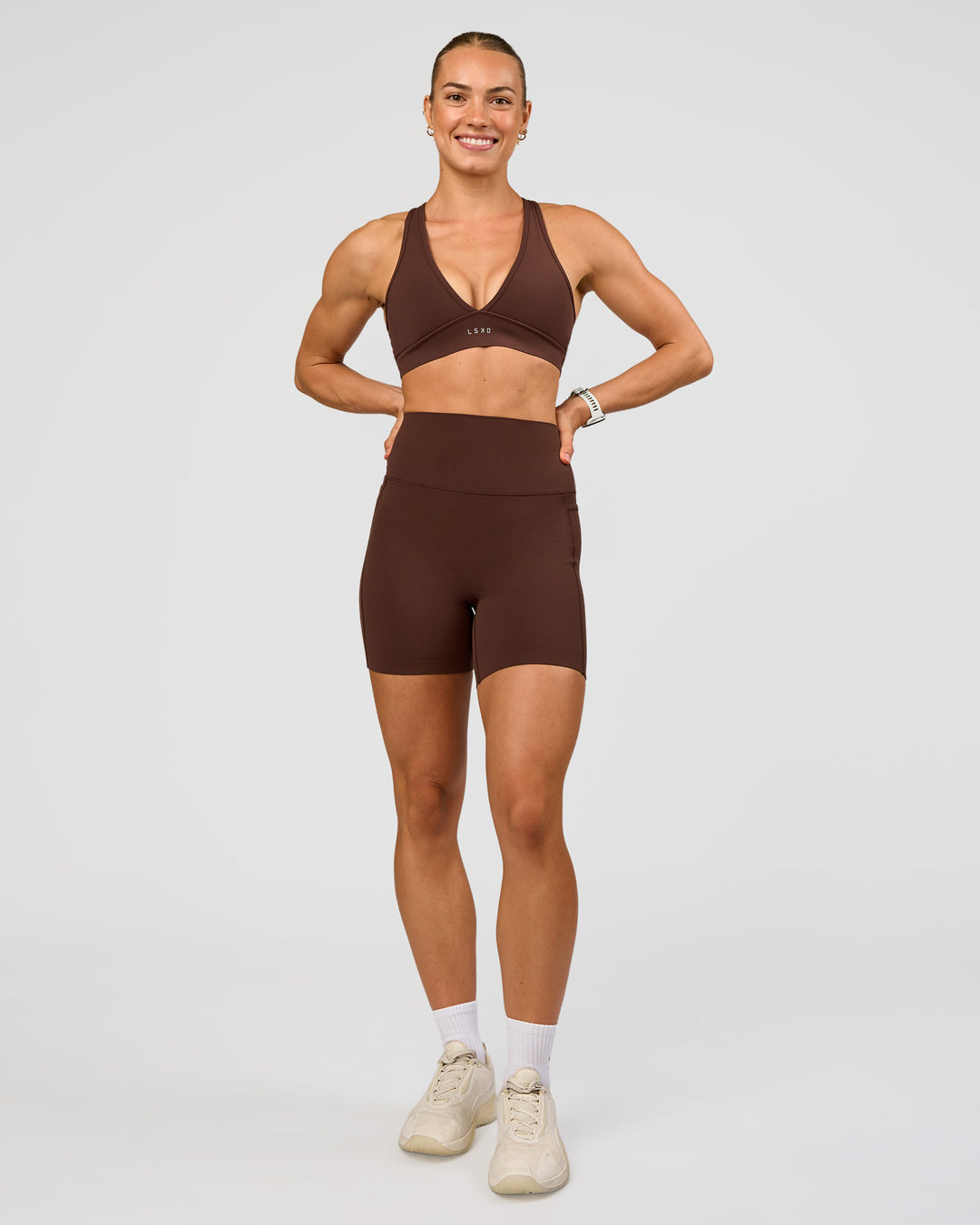 Woman wearing Elixir Ultra High-Rise 6” Short Pockets - Hot Chocolate | Model:Maja | Size:XS