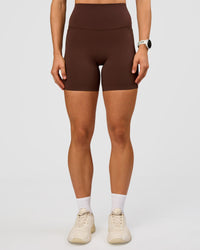 Woman wearing Elixir Ultra High-Rise 6” Short Pockets - Hot Chocolate | Model:Maja | Size:XS