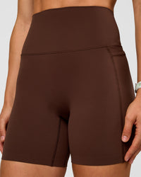 Woman wearing Elixir Ultra High-Rise 6” Short Pockets - Hot Chocolate | Model:Maja | Size:XS