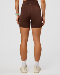 Woman wearing Elixir Ultra High-Rise 6” Short Pockets - Hot Chocolate | Model:Maja | Size:XS