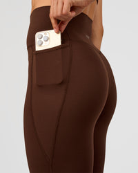 Woman wearing Elixir Ultra High-Rise 7/8 Legging Pockets - Hot Chocolate | Model:Maja | Size:XS