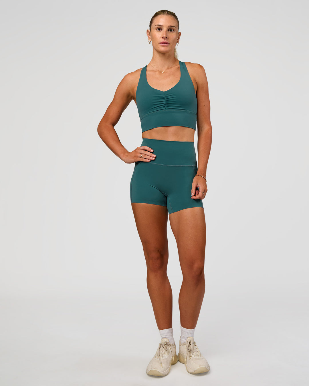 Woman wearing Evoke Longline Sports Bra - Transformative Teal | Model:Emelia | Size:XS