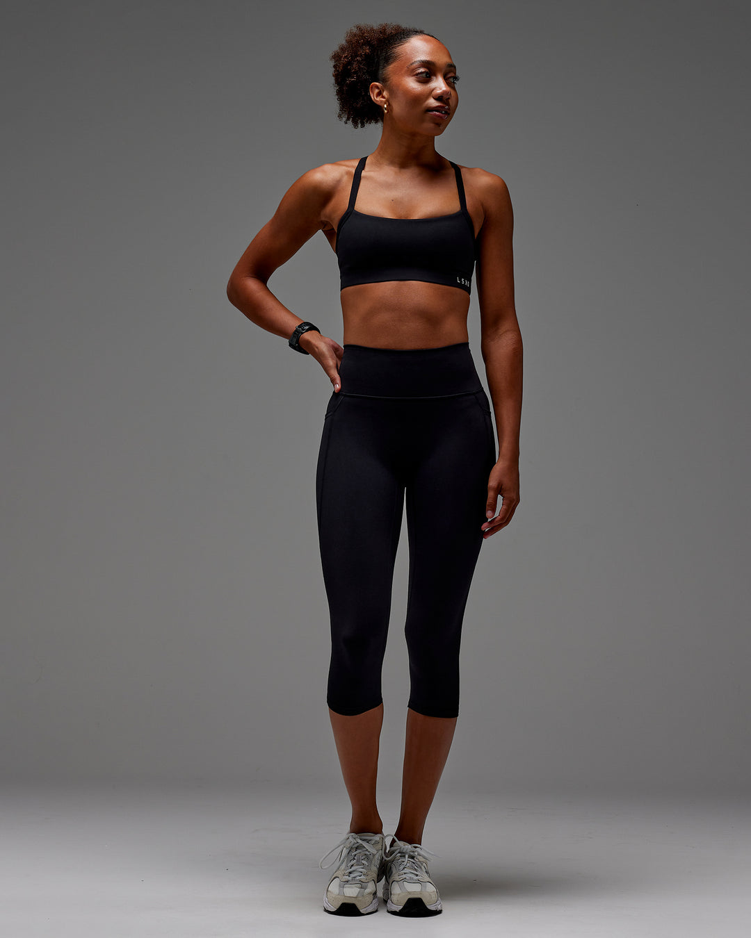 Woman wearing Fusion Ultra High-Rise 3/4 Legging Pockets - Black | Model:Txai | Size:XS