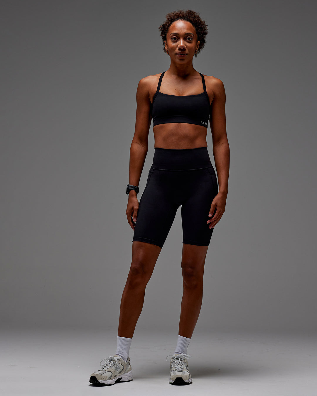Woman wearing Fusion Ultra High-Rise 9&quot; Short Pockets - Black | Model:Txai | Size:XS
