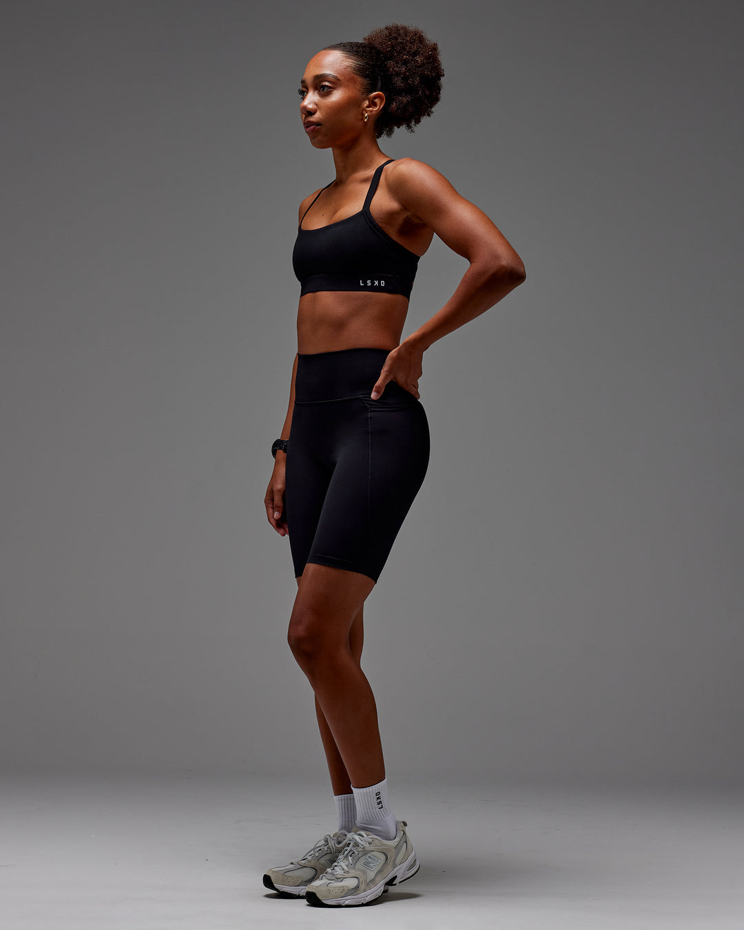 Woman wearing Fusion Ultra High-Rise 9&quot; Short Pockets - Black | Model:Txai | Size:XS