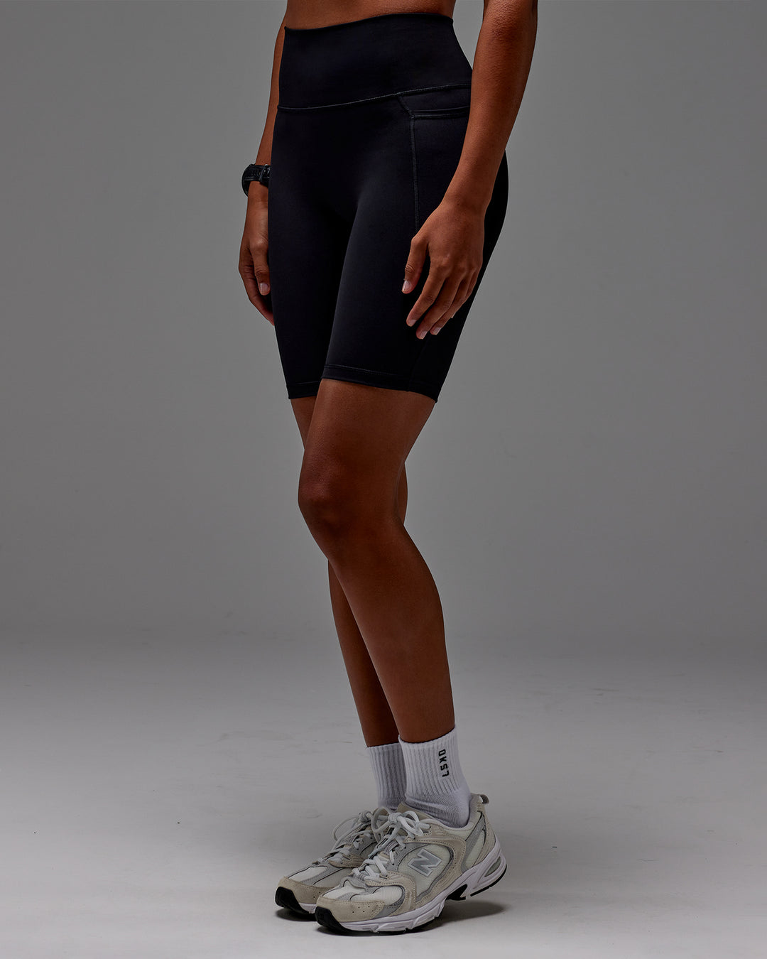Woman wearing Fusion Ultra High-Rise 9&quot; Short Pockets - Black | Model:Txai | Size:XS