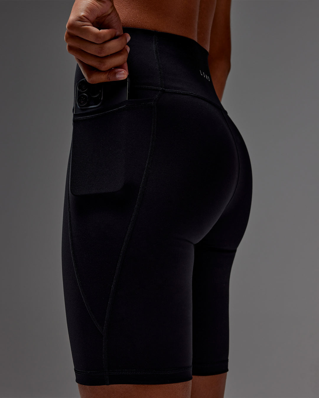 Woman wearing Fusion Ultra High-Rise 9&quot; Short Pockets - Black | Model:Txai | Size:XS