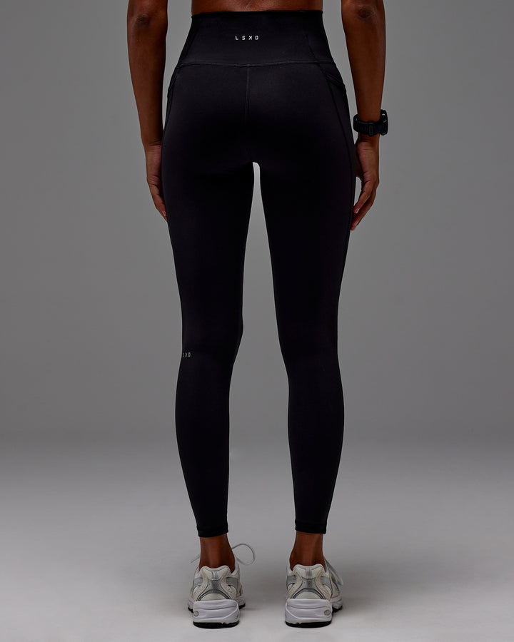 Woman wearing Fusion Full Length Tight With Pockets in Black | Model: Txai | Size:XS
