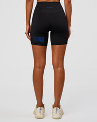 Woman wearing Fusion Hype Graphic Ultra High-Rise 6" Short Pockets - Black-Electric Indigo | Model:Charli | Size:XS
