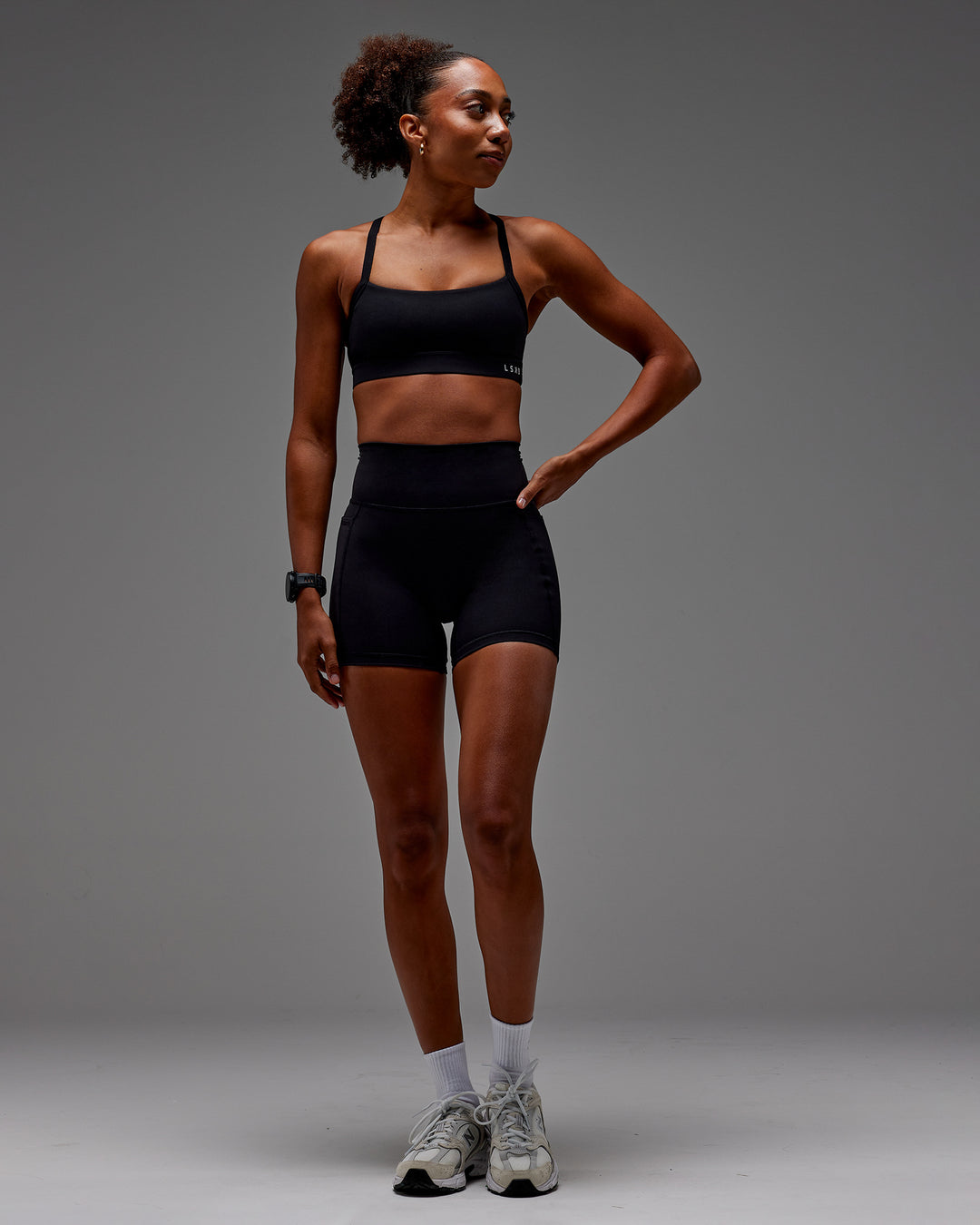Woman wearing Fusion Ultra High-Rise 6&quot; Short Pockets - Black | Model:Txai | Size:XS