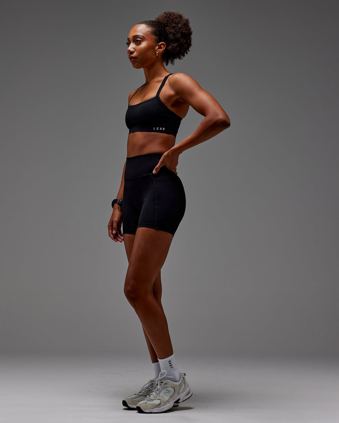 Woman wearing Fusion Ultra High-Rise 6&quot; Short Pockets - Black | Model:Txai | Size:XS