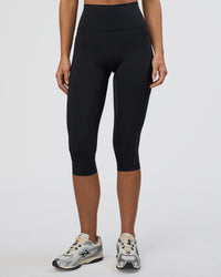 Woman wearing Fusion Ultra High-Rise 3/4 Legging Pockets - Black | Model:Eliza | Size:XS