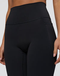 Woman wearing Fusion Ultra High-Rise 3/4 Legging Pockets - Black | Model:Eliza | Size:XS