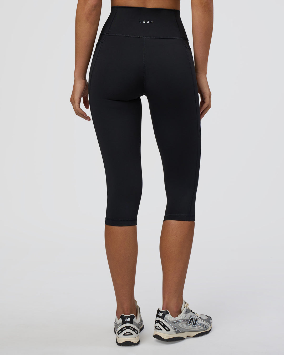Woman wearing Fusion Ultra High-Rise 3/4 Legging Pockets - Black | Model:Eliza | Size:XS