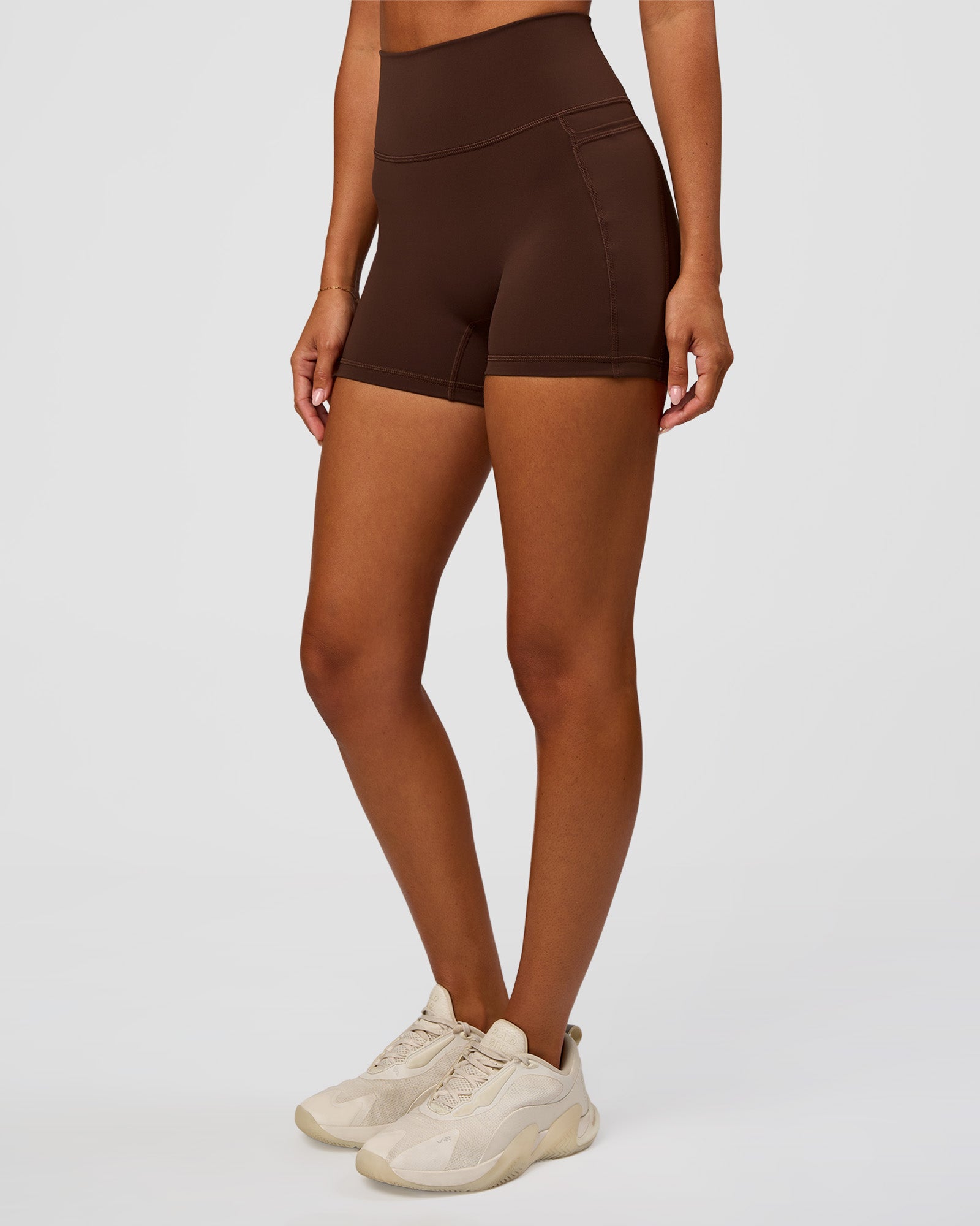 Woman wearing Fusion Ultra High-Rise 4" Short Pockets - Hot Chocolate | Set:true | Angle:side | Model:Charli | Size:XS