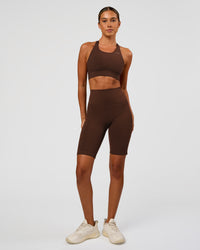 Woman wearing Fusion Ultra High-Rise 9" Short Pockets - Hot Chocolate | Model:Charli | Size:XS
