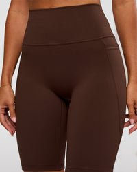 Woman wearing Fusion Ultra High-Rise 9" Short Pockets - Hot Chocolate | Model:Charli | Size:XS
