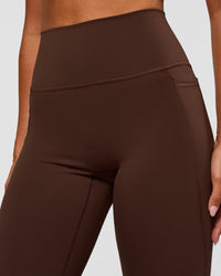 Woman wearing Fusion Ultra High-Rise Flared Legging Pockets - Hot Chocolate | Model:Charli | Size:XS