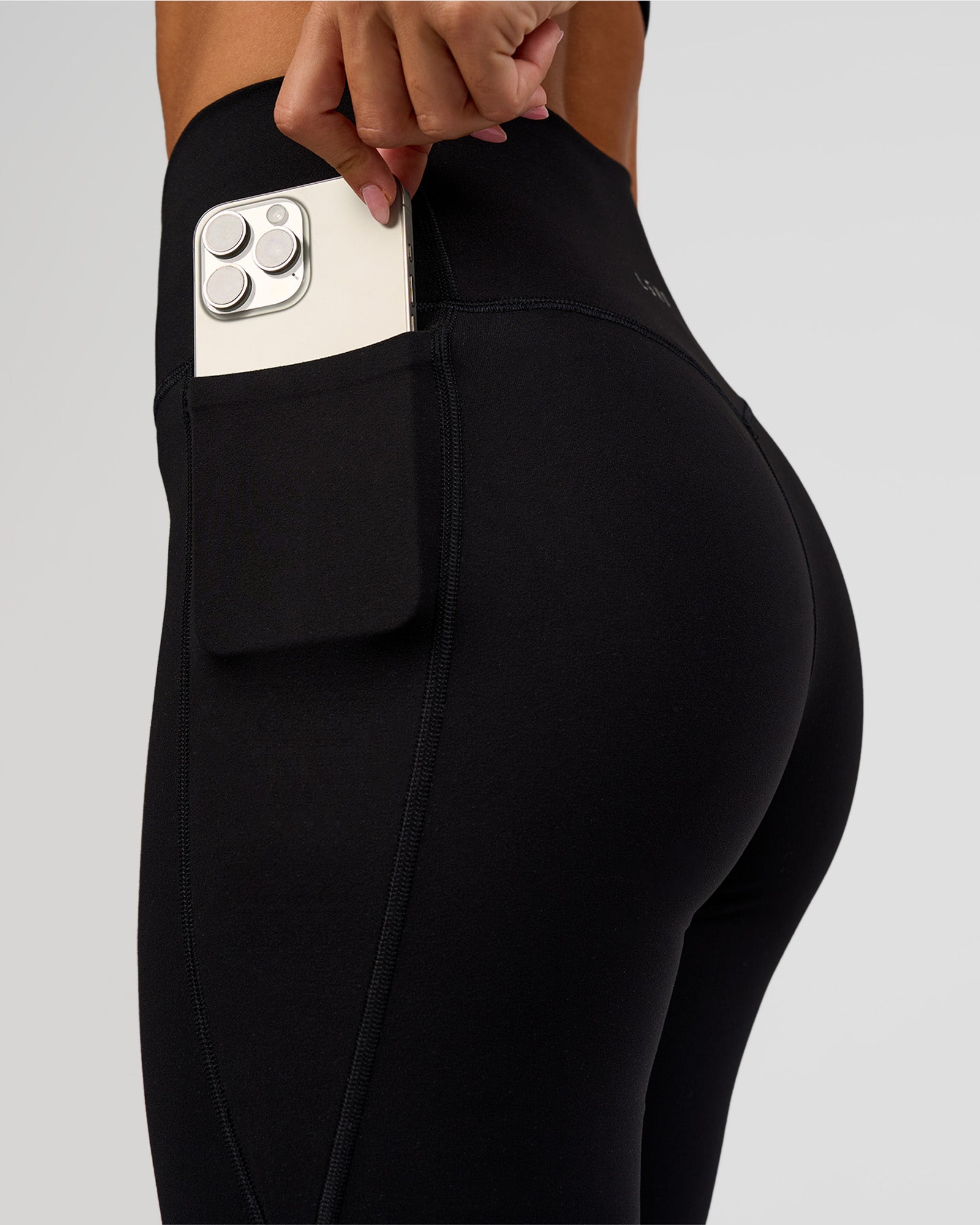 Woman wearing Fusion V-Contour High-Rise Flared Legging Pockets - Black | Model:Charli | Size:XS