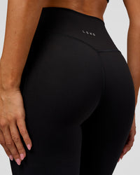 Woman wearing Fusion V-Contour High-Rise Flared Legging Pockets - Black | Model:Charli | Size:XS