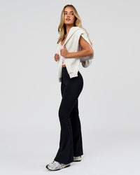 Woman wearing Fusion V-Contour High-Rise Flared Petite Legging Pockets - Black | Model:Issy | Size:XS