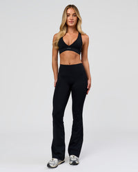 Woman wearing Fusion V-Contour High-Rise Flared Petite Legging Pockets - Black | Model:Issy | Size:XS