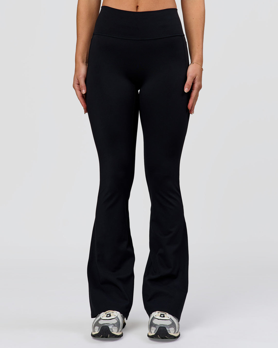 Woman wearing Fusion V-Contour High-Rise Flared Petite Legging Pockets - Black | Model:Issy | Size:XS