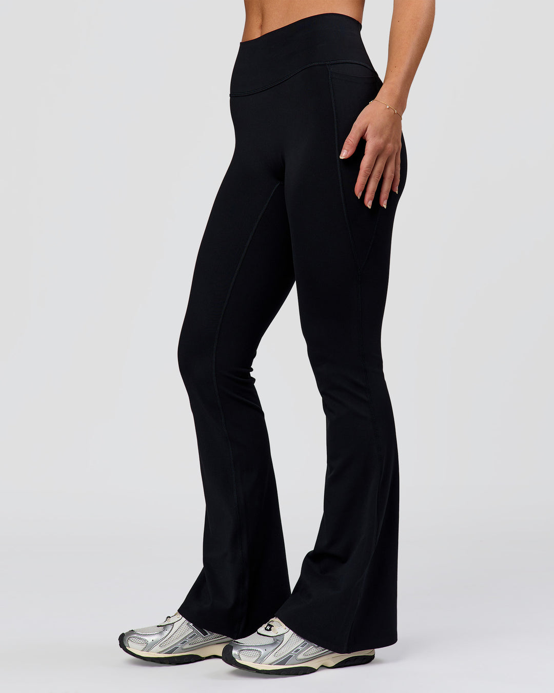 Woman wearing Fusion V-Contour High-Rise Flared Petite Legging Pockets - Black | Model:Issy | Size:XS