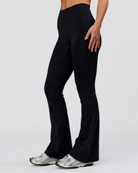 Woman wearing Fusion V-Contour High-Rise Flared Petite Legging Pockets - Black | Model:Issy | Size:XS