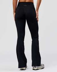 Woman wearing Fusion V-Contour High-Rise Flared Petite Legging Pockets - Black | Model:Issy | Size:XS