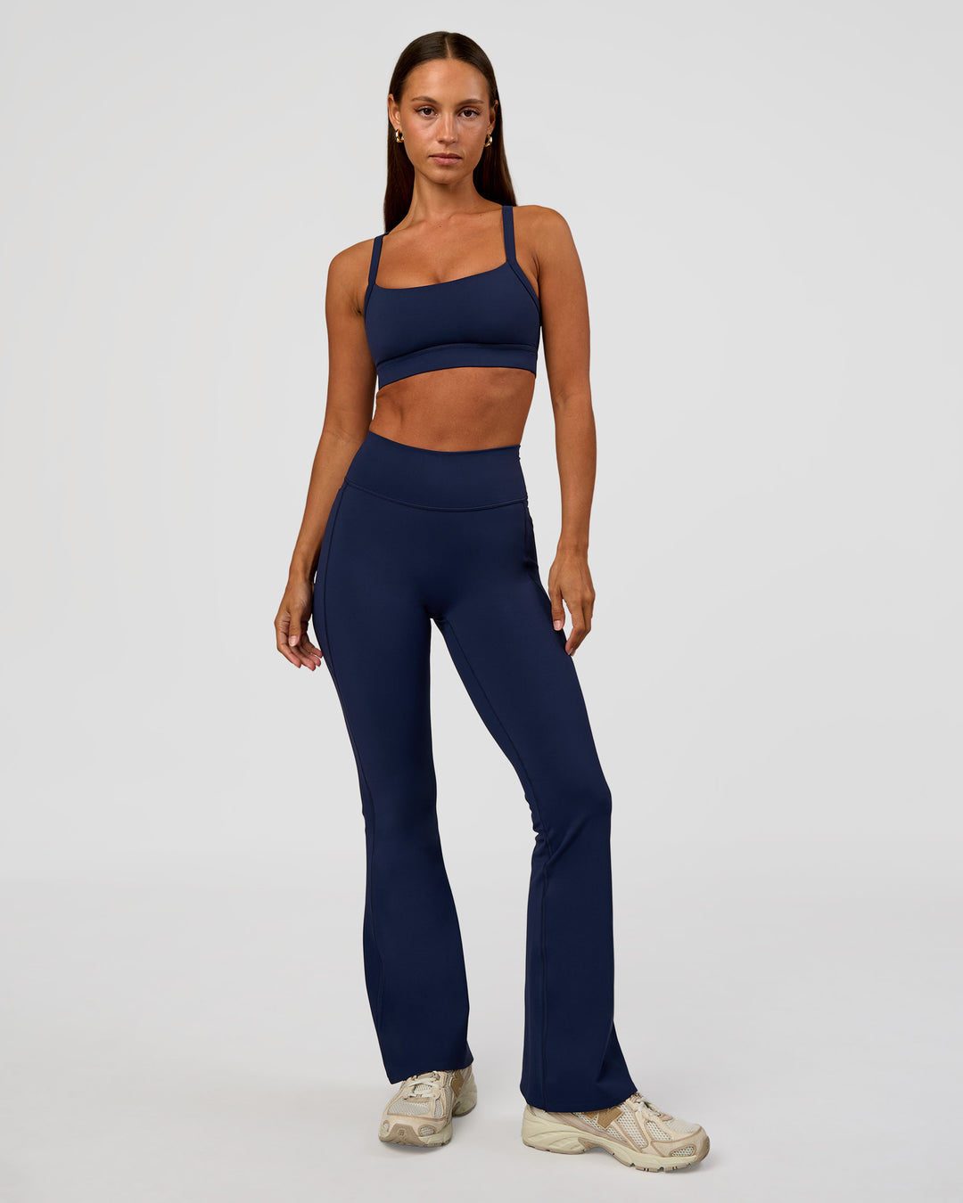 Woman wearing Fusion V-Contour High-Rise Flared Petite Legging Pockets - Future Navy | Model:Brylee | Size:XS